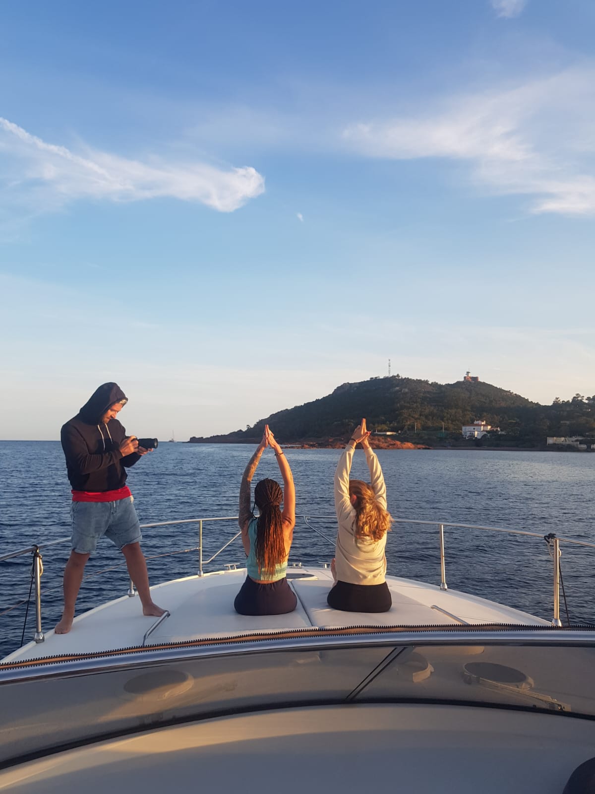 Séance de yoga en groupe sur un bateau au large