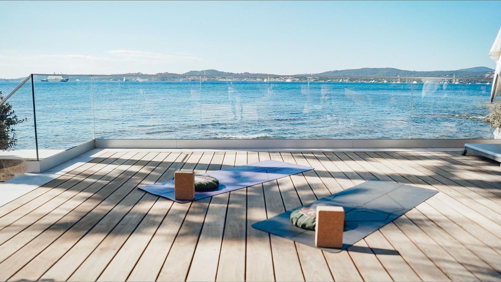 Deux tapis de yoga installés sur une terrasse face à la mer